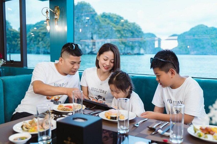 A group of people dining at a table with a scenic waterfront view. 5