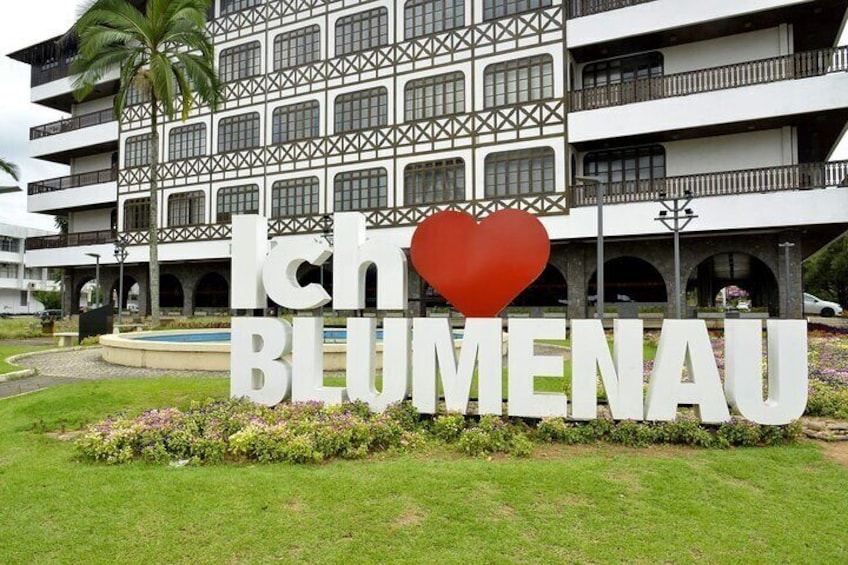 A building with a sign that reads "Ich BLUMENAU" and a heart symbol. 1