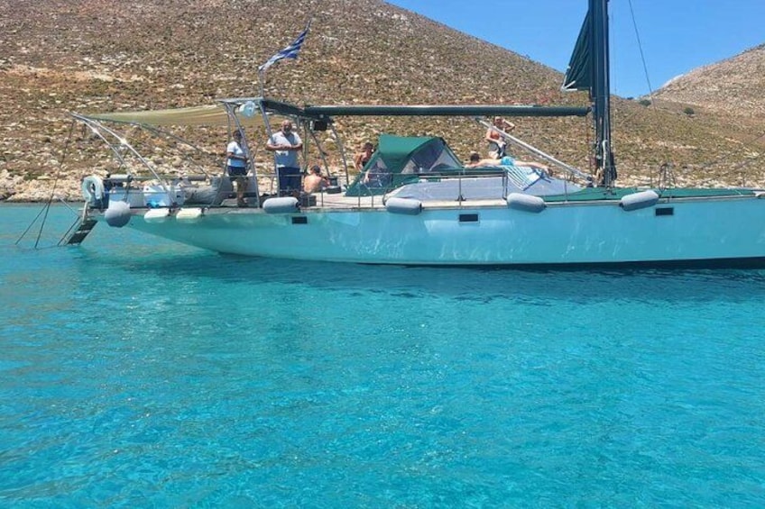 Un velero en aguas turquesas cristalinas con un paisaje montañoso al fondo. 3