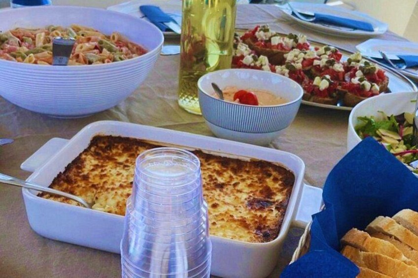 Un repas composé de pâtes, d’un plat gratiné et de pain, servis sur une table. 3