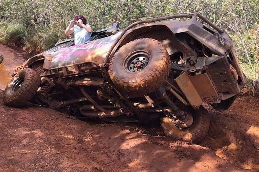 Ein geländegängiges Fahrzeug mit vier Rädern steckt im Schlamm, während eine Person ein Foto macht. 3
