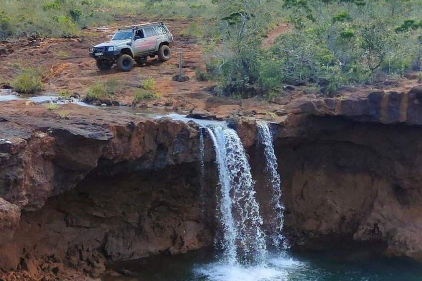 Een waterval, rotsachtig terrein en een voertuig. 4