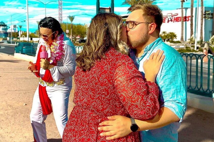 A person in a white suit with a pink drink, another in a red patterned dress, and a third in a blue shirt. 3