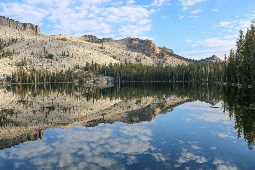 A calm lake reflecting mountains and trees. 2