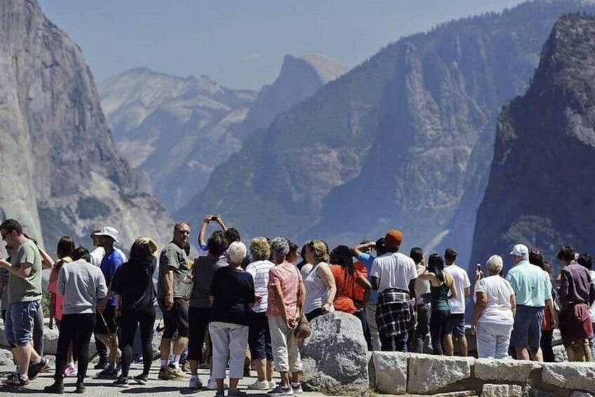 Un grupo de personas de pie sobre un risco, contemplando un paisaje montañoso. 3