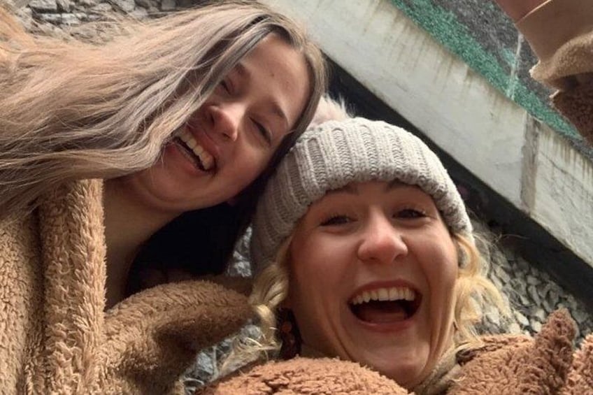 Two people embracing, one wearing a brown coat and the other a grey hat. 3