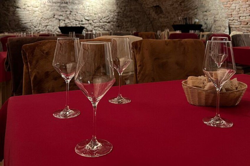 A table with three wine glasses and a basket of bread in a restaurant. 3