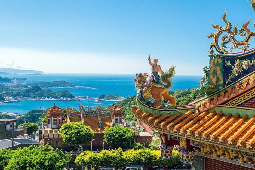 A traditional Chinese building with ornate roofs and a dragon statue. 1