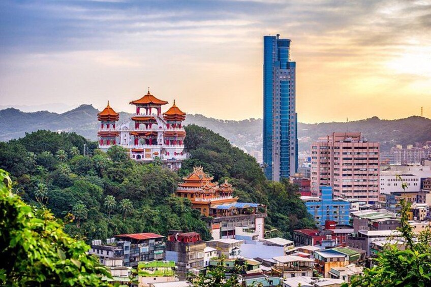 A cityscape with traditional multi-tiered buildings, modern high-rise buildings, and a lush green hillside. 5