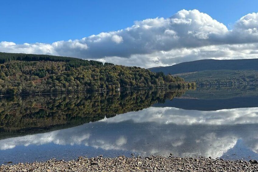 Un lac paisible où se reflètent les arbres et les collines. 3