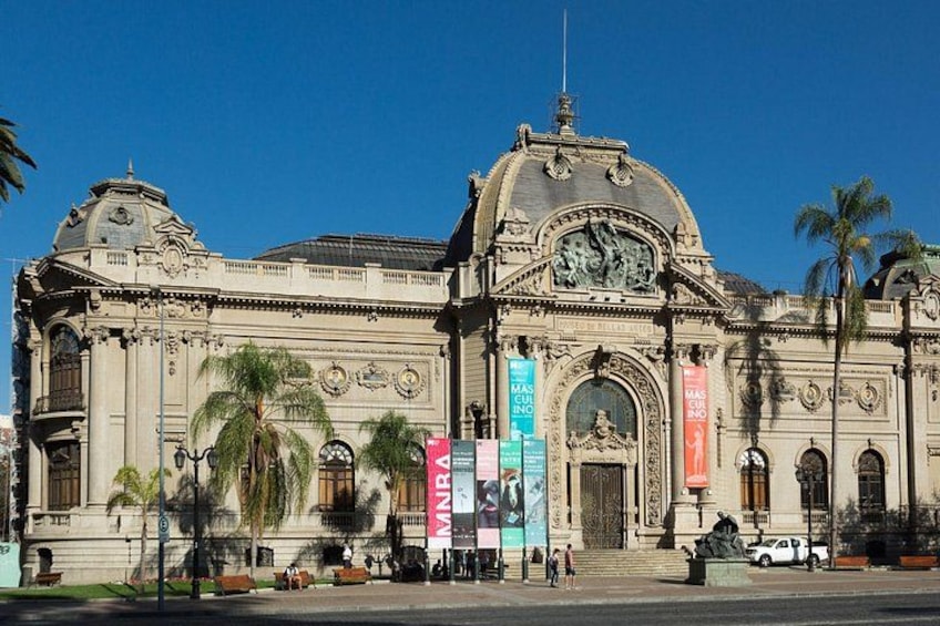 A large, ornate building with a dome and columns, palm trees, and banners. 3