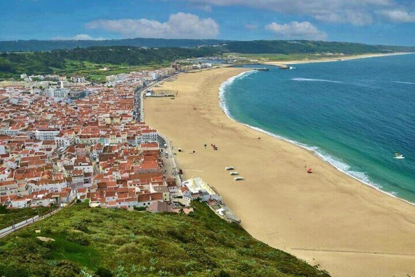 A coastal town with a beach, buildings, and a clear sky. 3