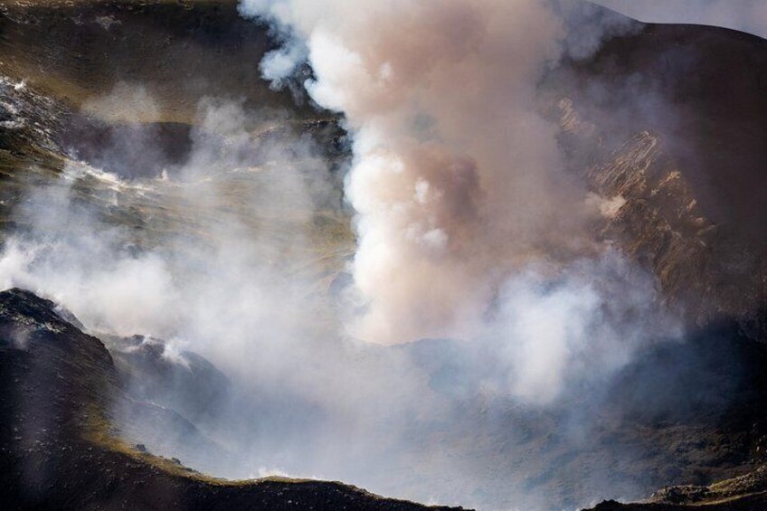 A volcanic landscape with smoke rising from the ground. 5