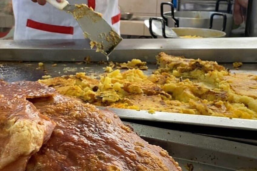 Una persona sirviendo comida desde una bandeja grande. 2