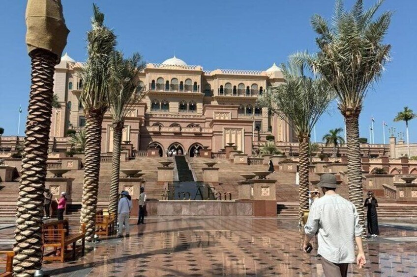 A large building with arches and palm trees in a courtyard. 2