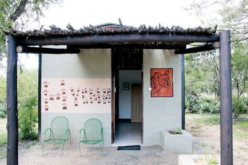 A small structure with a roof, a wall with animal paw prints, and a bear illustration. 2