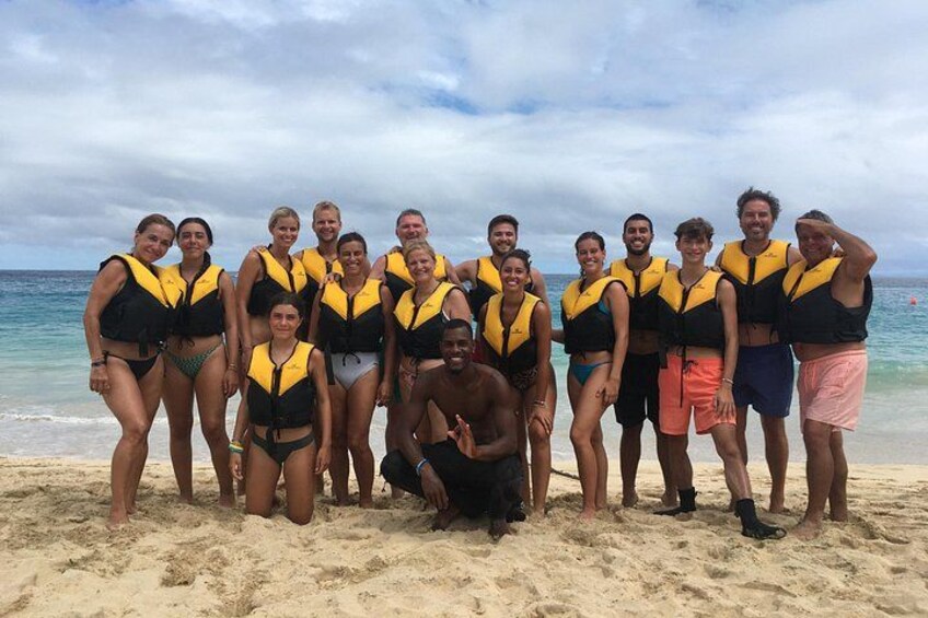 Een groep mensen op een strand, gekleed in reddingsvesten. 2