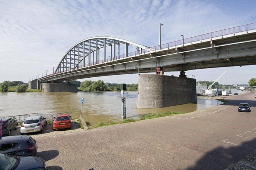 Un ponte sopra un fiume, con auto parcheggiate sul lato. 2