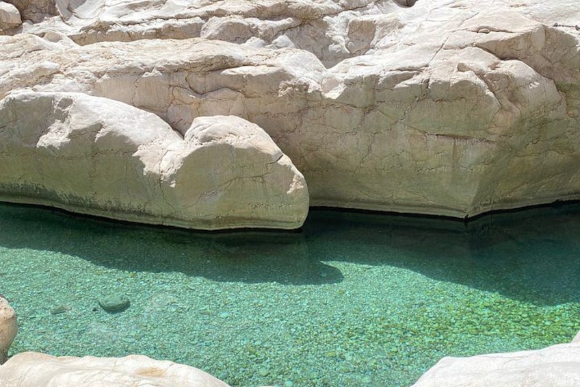 Une grande formation rocheuse avec une étendue d’eau claire en contrebas. 3