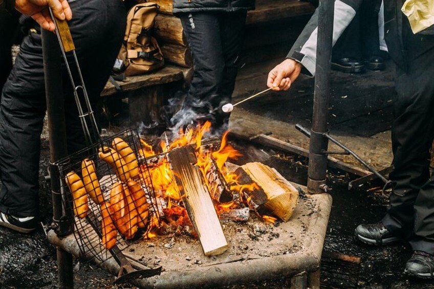 Une personne qui fait griller des saucisses sur une flamme nue. 2