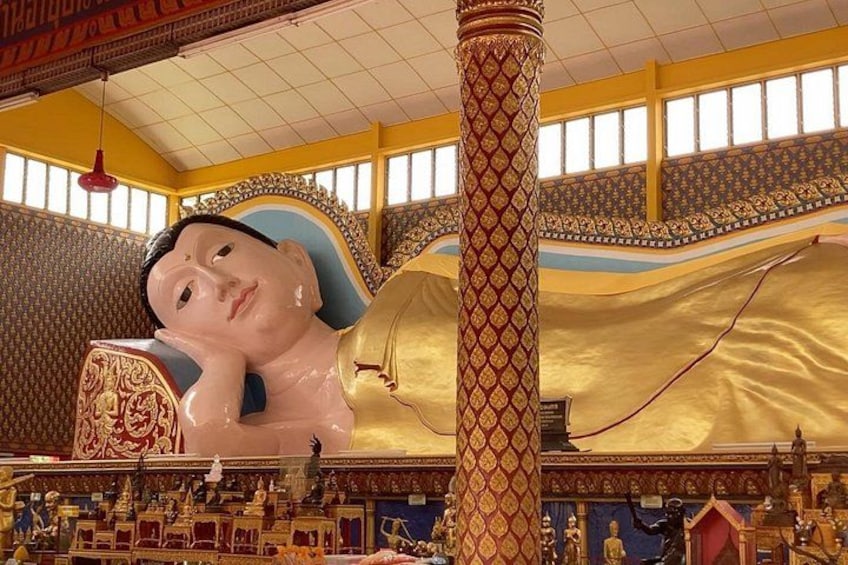 En stor Buddha-statue i et tempel med detaljerede udsmykninger og gyldne elementer. 4