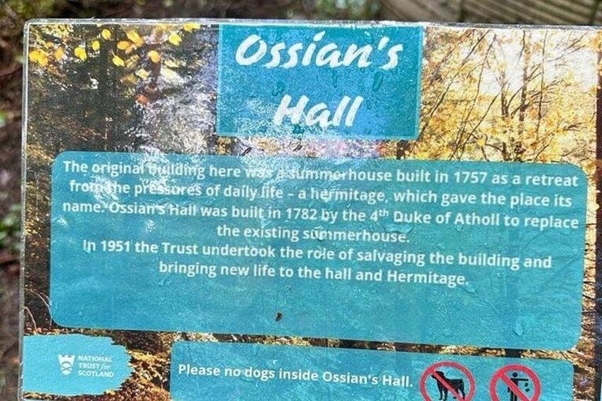 Un letrero histórico sobre Ossian's Hall, con texto y un cartel de prohibición para perros. 4