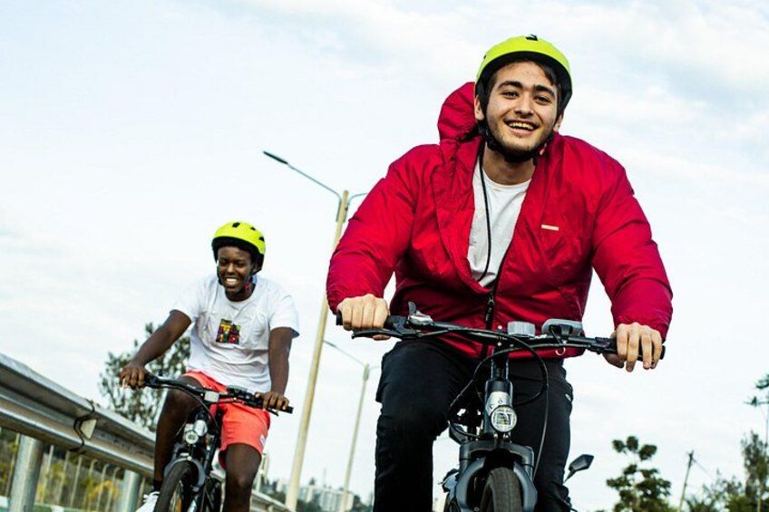 Två personer cyklar på en bro med en klar himmel. 2