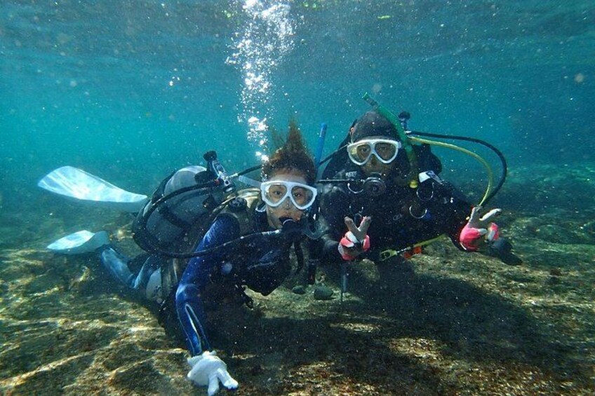 Two scuba divers underwater with fins and scuba gear. 4