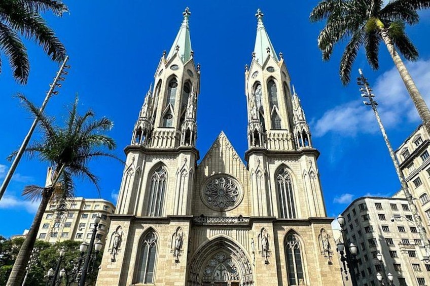 A cathedral with two tall spires, a large clock, and a dome. 1
