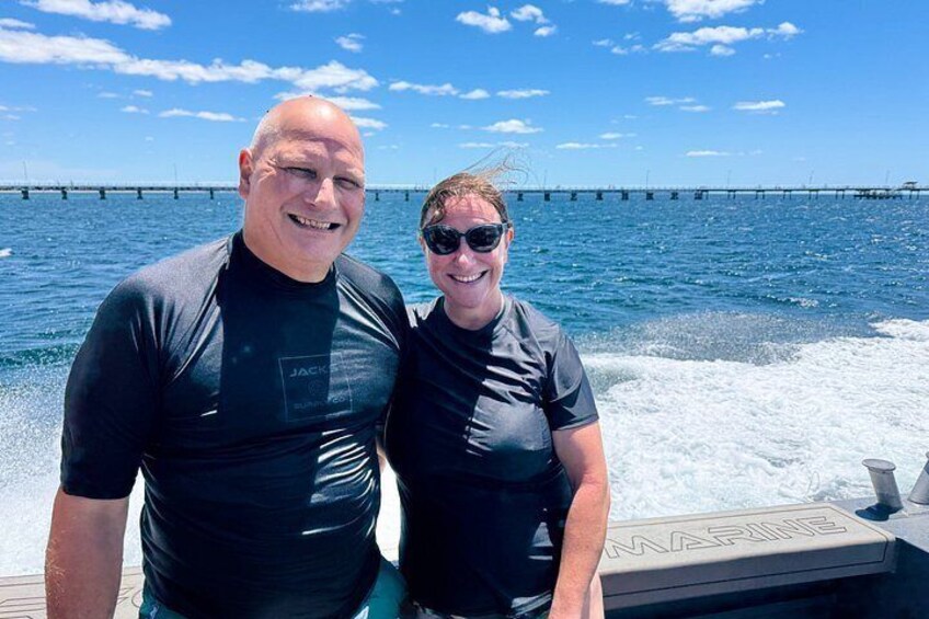 Two people on a boat with a pier in the background. 4