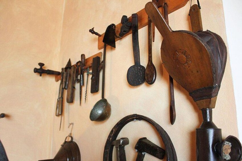 Una selezione di utensili e strumenti antichi appesi a una parete. 3