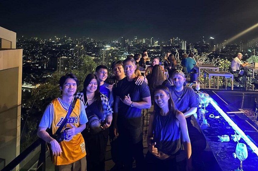 Un grupo de personas en una azotea con un paisaje urbano de fondo. 4