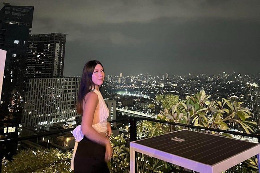 Una persona de pie en un balcón con vistas a un paisaje urbano nocturno. 2