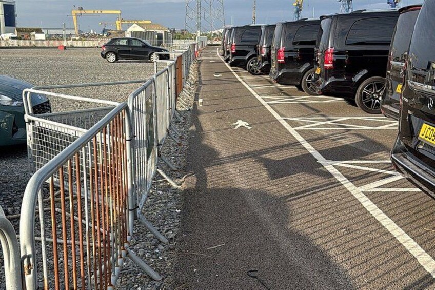 A parking lot with vehicles and metal barriers. 5