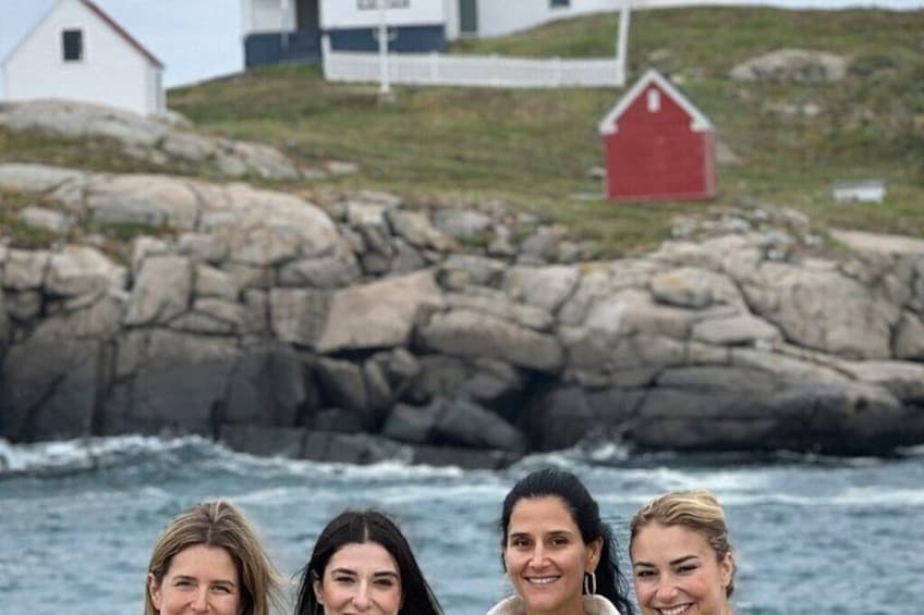 A rocky coastline with a white building and a red barn. 3