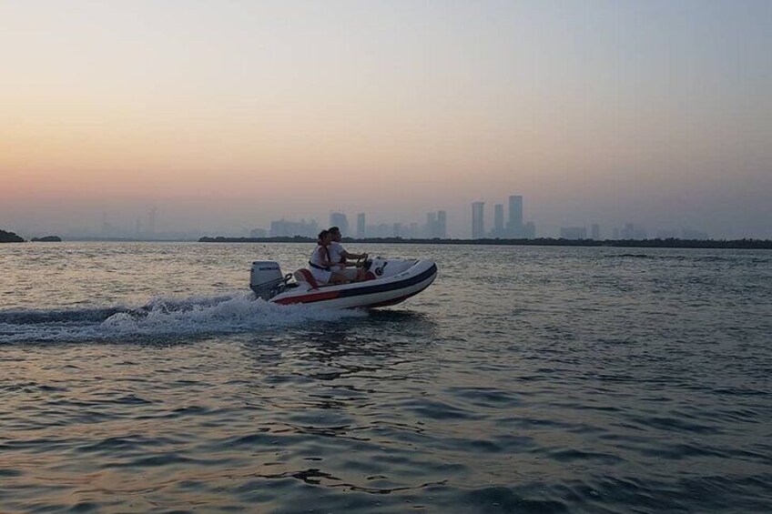 A person riding a jet ski on a body of water with a city skyline in the background. 2