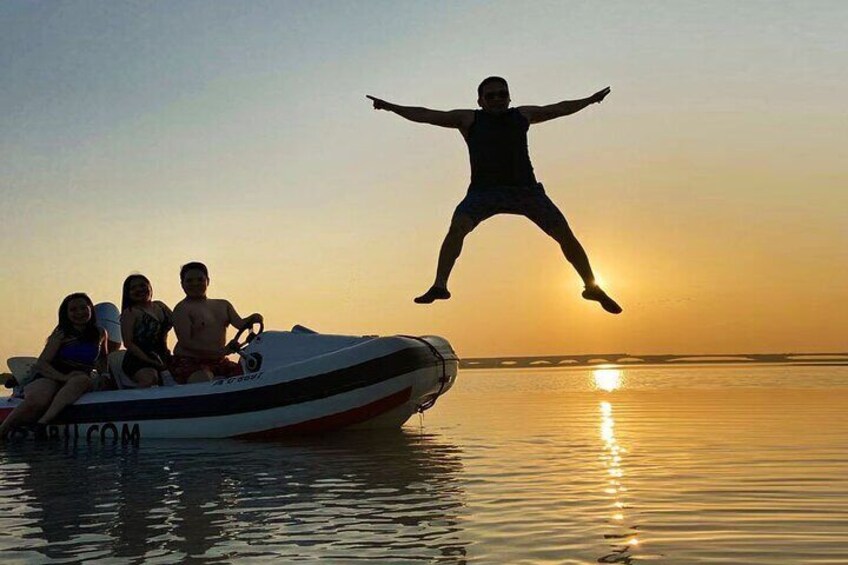 A person jumping off a boat at sunset. 3