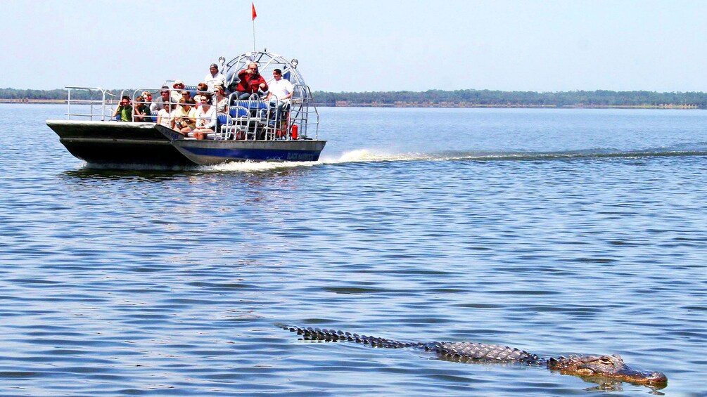 A boat with people on it moving across a body of water. 3
