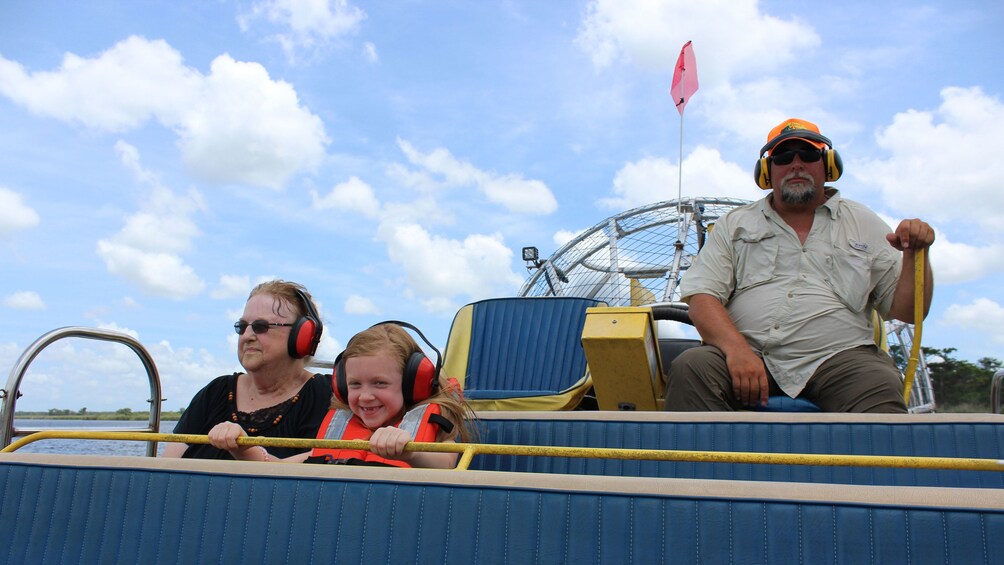 A Ferris wheel, a person in a hat and sunglasses, and two people in safety harnesses on a ride. 4