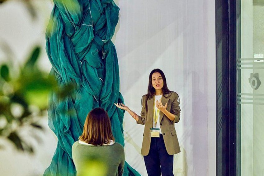 A person presenting in front of a large green fabric structure. 3