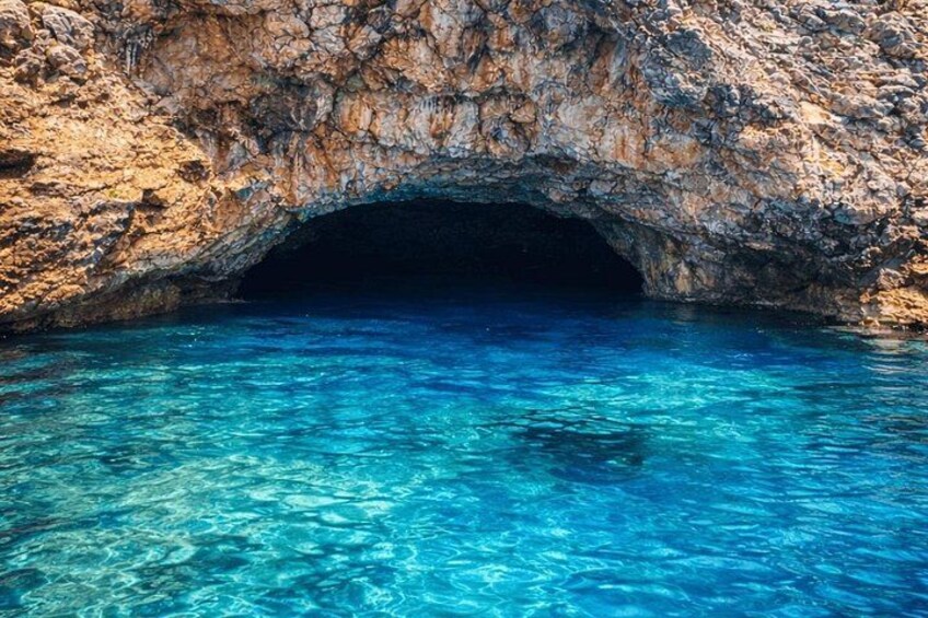 L'imboccatura rocciosa di una grotta con acqua cristallina blu. 3