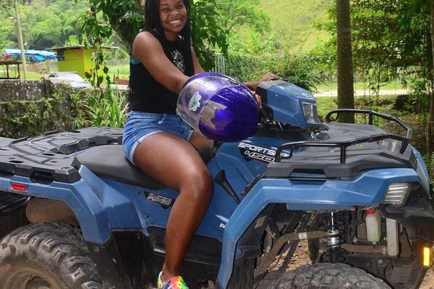 A person sitting on a blue ATV with a purple helmet. 3