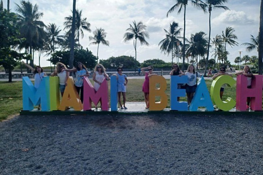 People standing behind colorful letters spelling 'MIAMI BEACH.' 3