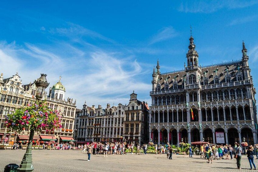 Una piazza europea storica con edifici decorati, una folla di persone e un cielo azzurro limpido. 5
