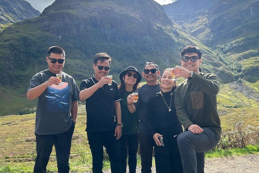 Eine Gruppe von Menschen draußen vor einer gebirgigen Landschaft. 1