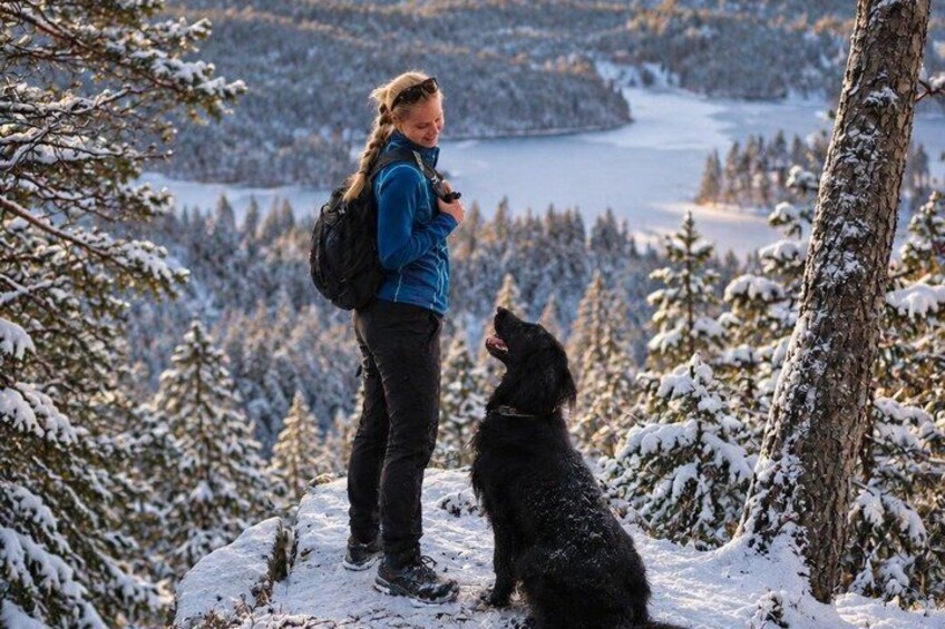 A person standing on a snowy mountain with a dog. 1
