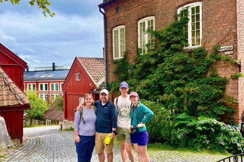 A cobblestone street, red buildings, and greenery. 2