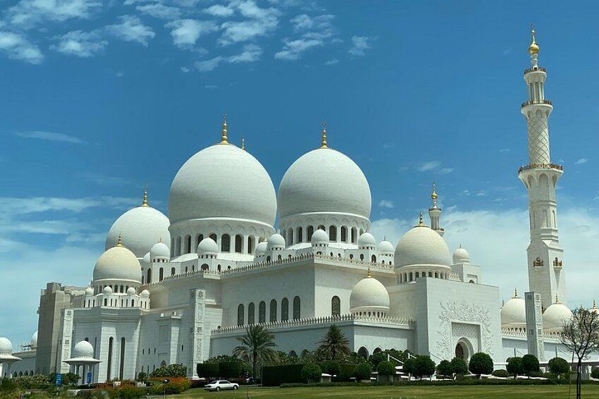 A large white mosque with multiple domes and a tall minaret. 2