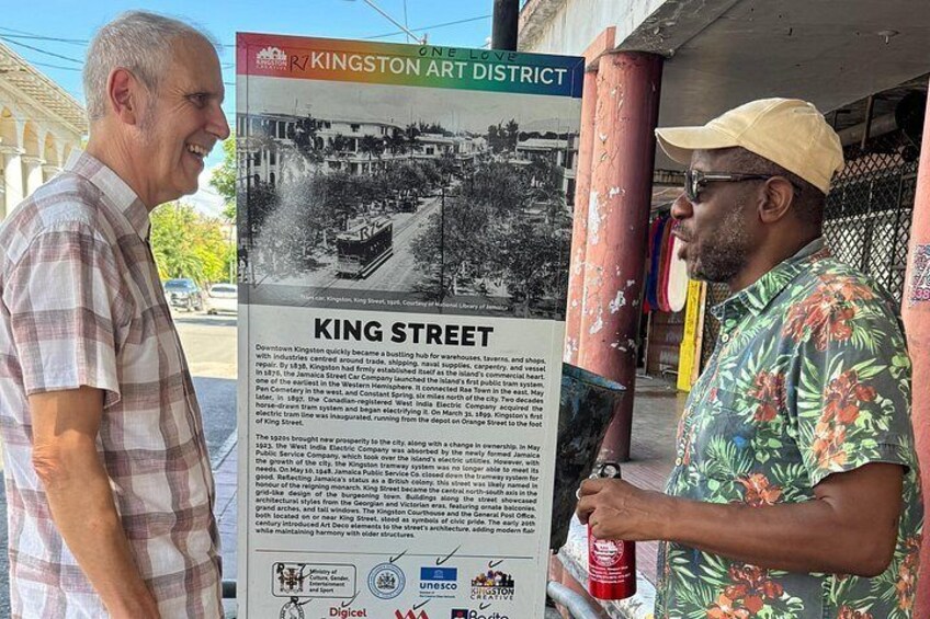 Deux hommes se tiennent devant un panneau commémoratif indiquant « RUE KING » et qui contient une description détaillée de l’histoire de cette rue. 3