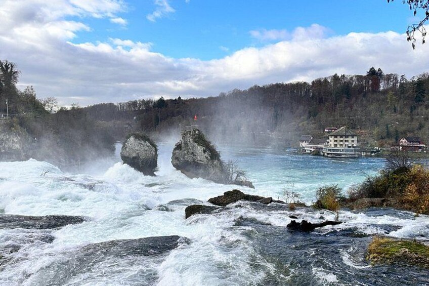 Ein Fluss mit Stromschnellen, ein Hausboot und ein bewaldeter Hang. 2